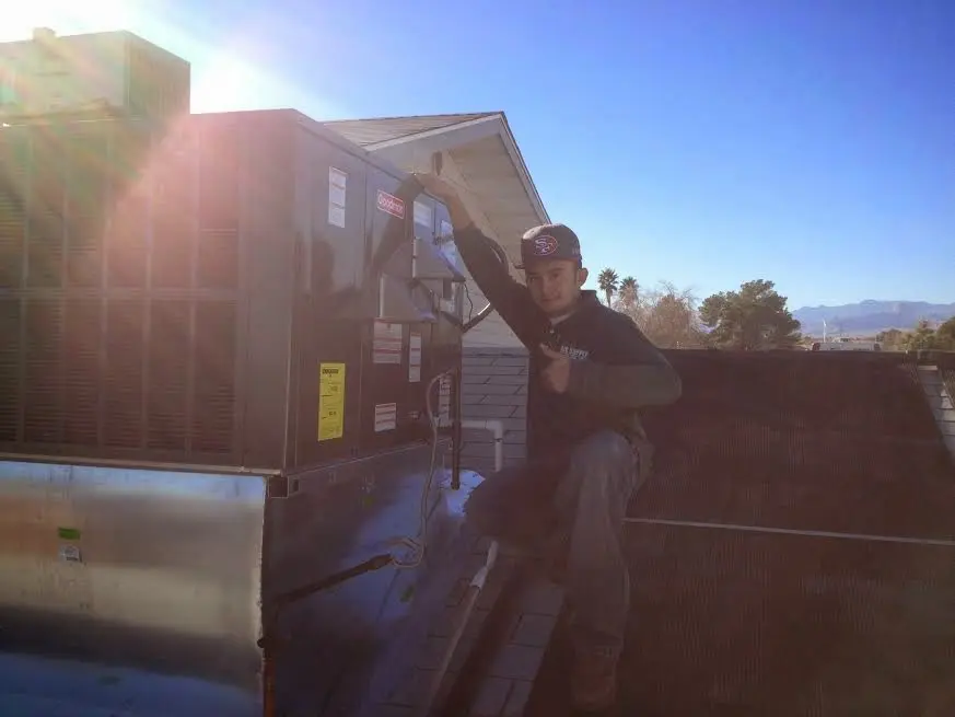 HVAC technician performing AC Tune-Up on a rooftop unit in Dolton
